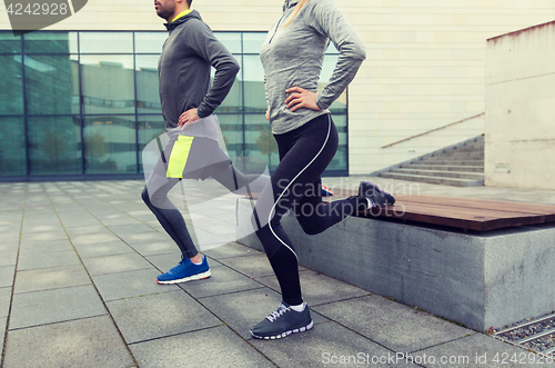 Image of close up of couple doing lunge exercise on street