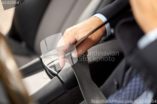 Image of senior businessman fastening car seat belt