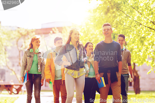 Image of group of happy teenage students walking outdoors