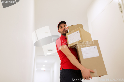 Image of delivery man with parcel boxes in corridor