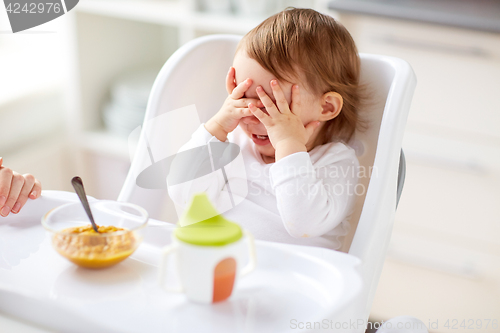 Image of baby sitting in highchair and eating at home