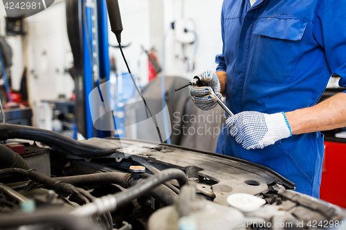 Image of mechanic man with wrench repairing car at workshop