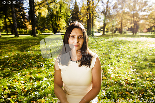 Image of mature real brunette woman in green spring park, lifestyle conce