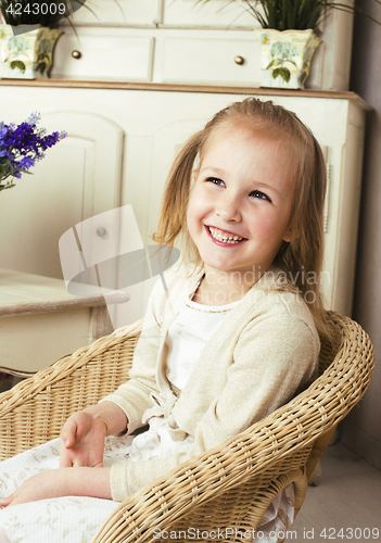 Image of little cute blonde european girl playing at home interior, lifes