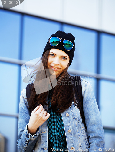 Image of young pretty girl near business building walking