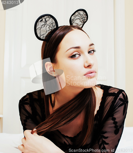 Image of young pretty brunette woman wearing sexy lace mouse ears, laying