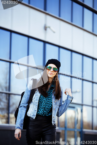 Image of young pretty girl near business building walking