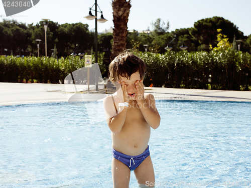 Image of little cute real boy in swimming pool close up smiling