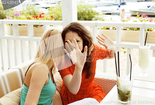 Image of portrait of two pretty modern girl friends in cafe open air inte