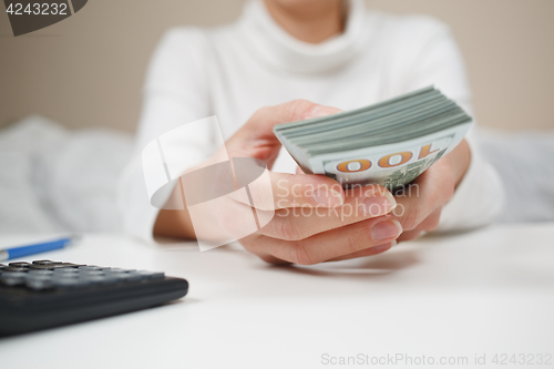 Image of Close up of woman with calculator counting money