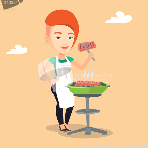 Image of Woman cooking steak on barbecue grill.