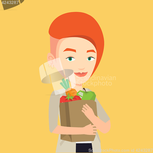 Image of Happy woman holding grocery shopping bag.