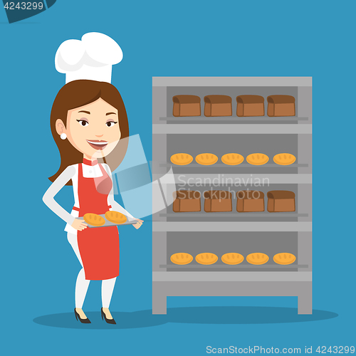 Image of Happy young female baker holding tray of bread.