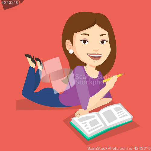 Image of Student laying on the floor and reading book.