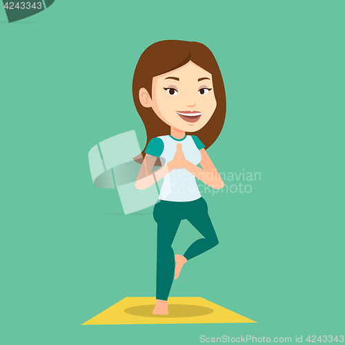 Image of Young woman practicing yoga tree pose.