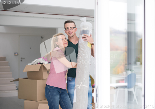 Image of couple carrying a carpet moving in to new home