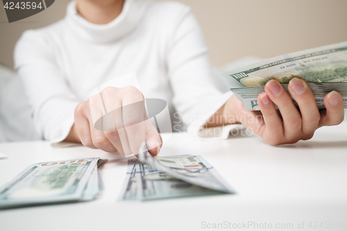 Image of Close up of woman with calculator counting money