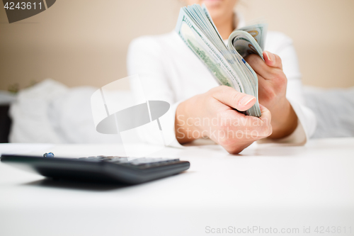 Image of business, finance, saving, banking and people concept - close up of woman hands counting us dollar money