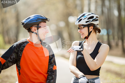 Image of Two cyclists stand at park