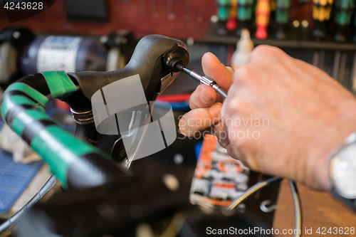 Image of Guy fixing bicycle handle screwdriver