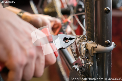 Image of Man with pliers repairing bicycle