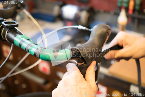 Image of Man repairing helm of bicycle