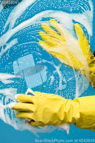 Image of Man washes window in gloves