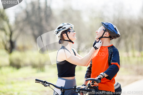 Image of Guy, girl wearing bicycle helmets