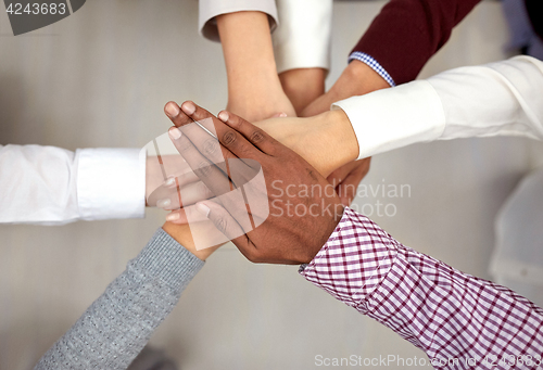 Image of business team with hands on top at office