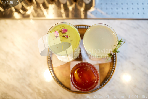 Image of tray with glasses of cocktails at bar