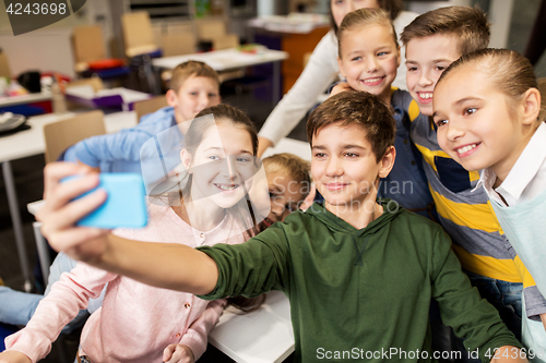 Image of group of school kids taking selfie with smartphone