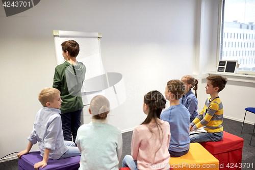 Image of student boy with marker writing on flip board