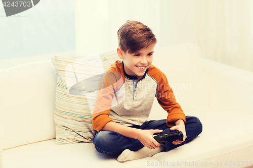 Image of happy boy with joystick playing video game at home