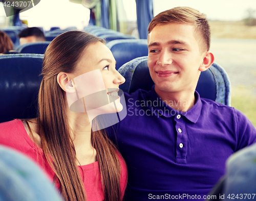 Image of happy teenage couple or passengers in travel bus