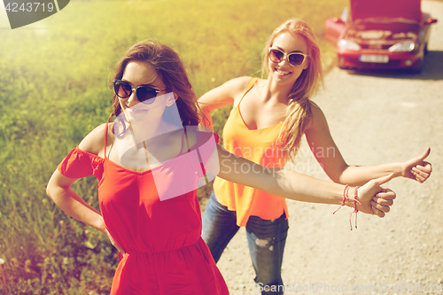 Image of women with broken car hitchhiking at countryside