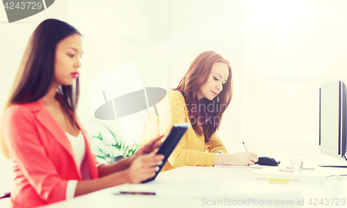 Image of creative female office worker writing to notebook
