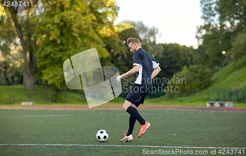 Image of soccer player playing with ball on football field