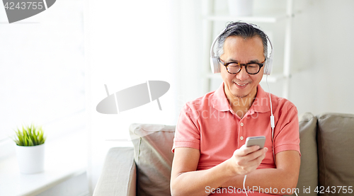 Image of man with smartphone and headphones at home