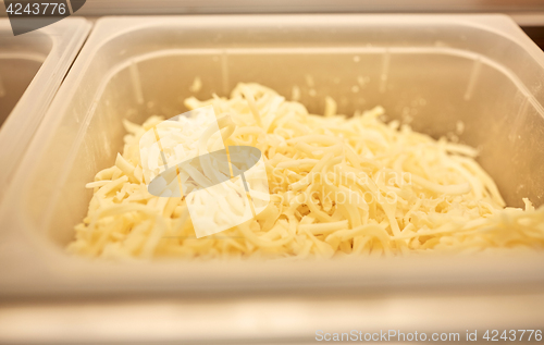 Image of container with grated cheese at restaurant kitchen