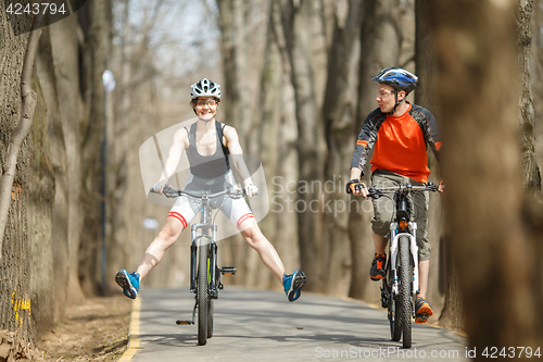 Image of Funny cyclists driving around park