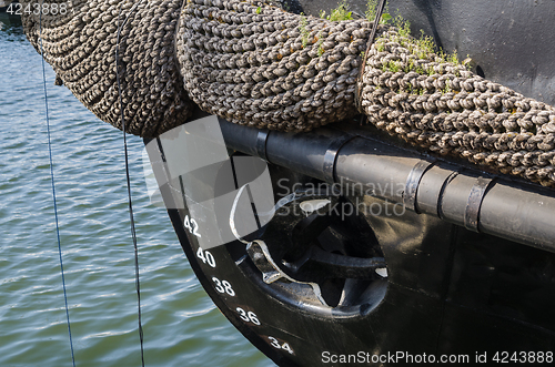 Image of Old rusty anchor at a board of the ship