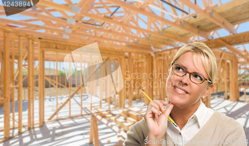 Image of Pensive Woman with Pencil On Site Inside New Home Construction F