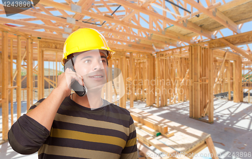 Image of Hispanic Contractor Using Phone On Site Inside New Home Construc