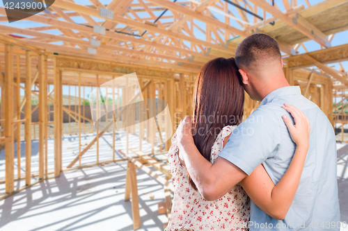 Image of Young Military Couple On Site Inside Their New Home Construction