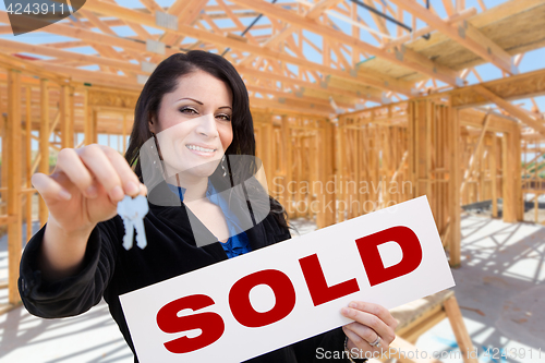 Image of Hispanic Woman With Keys and Sold Sign On Site Inside New Home C