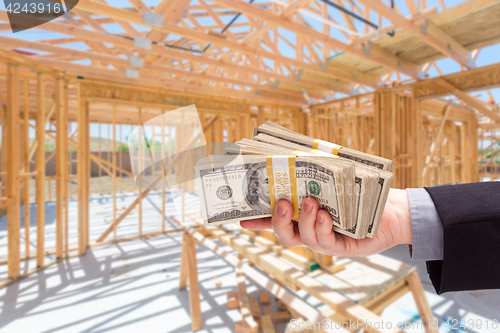 Image of Hand With Stacks of Cash On Site Inside New Home Construction Fr