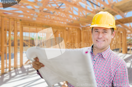 Image of Contractor With Plans On Site Inside New Home Construction Frami