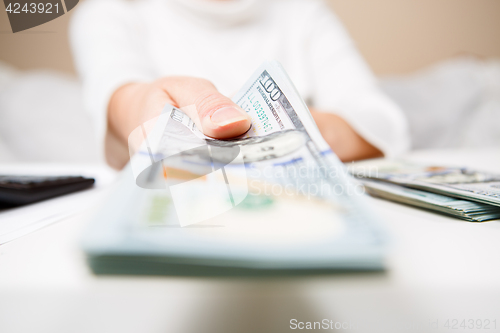 Image of Hands of person proposing money to you - closeup shot