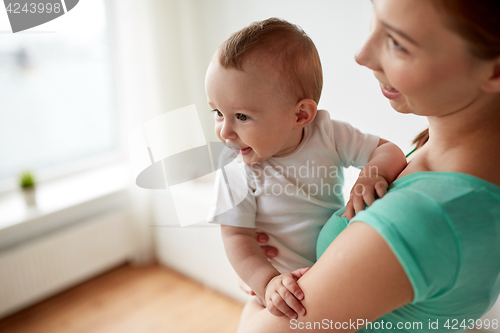 Image of happy young mother with little baby at home