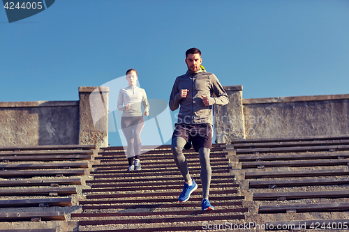 Image of couple running downstairs in city